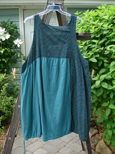 Barclay Linen Patchwork Pocket Draw Pinafore Dress Tealen Size 2: A blue dress with varying patterns of stripes and florals. Features a drawcord hem, a giant exterior tulip shape side pocket, and a back empire seam with a tiny little gather. Perfect for the summer collection.