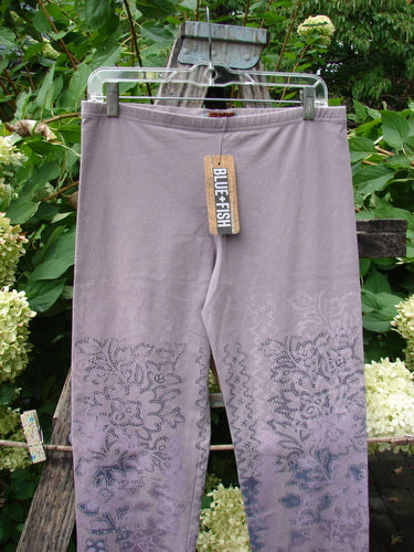 Barclay NWT Cotton Lycra Basic Legging Tiny Botanicals Sea Fog Size 1, hanging outdoors, features a muted lavender/gray color with a subtle botanical print on the lower legs, showcasing a forgiving, tapered design.