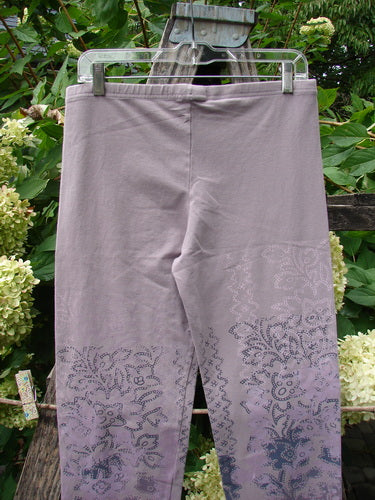 Barclay NWT Cotton Lycra Basic Legging Tiny Botanicals Sea Fog Size 1, featuring dusky lavender-gray hue with paisley print on lower legs, displayed outdoors against lush foliage.