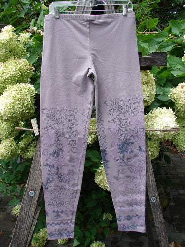 Barclay NWT Cotton Lycra Basic Legging Tiny Botanicals Sea Fog Size 1, featuring a tone-on-tone floral lower pattern, hanging on a clear hanger against a rustic outdoor backdrop.