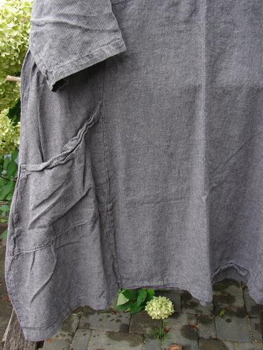Barclay NWT Linen Cross Over Urchin Dress Stripe Mineral Size 1, featuring a knee-length, loose-cut design with a smart V-neckline, short sleeves, and a large patch pocket, displayed outdoors.