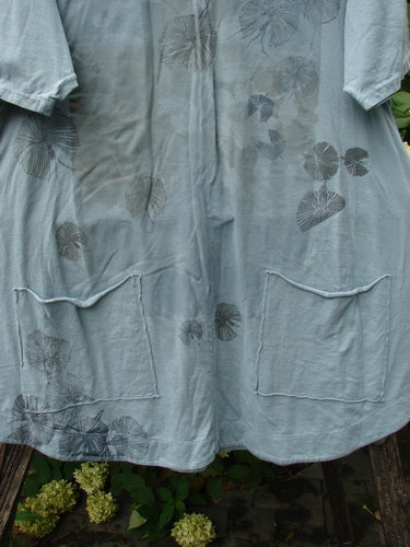 Barclay NWT Seedling Top Dandelion Early Blue Sky Size 1 features a loose, short-sleeved tunic with patch pockets and stylized leaf prints, showcasing an A-line design and scalloped hemline.