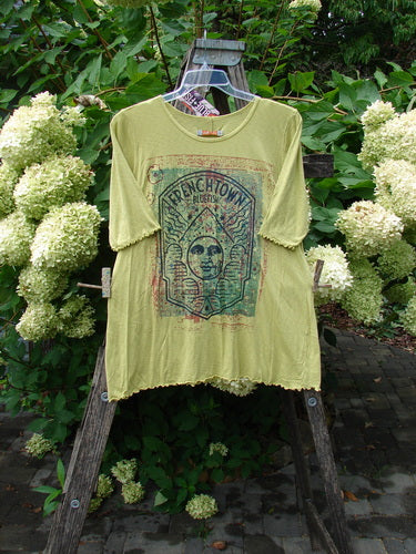 Barclay NWT Modal Slub Simple Tee Frenchtown Sun Gal Citron Size 1, displayed hanging outdoors, features a faded graphic and rounded neckline, highlighting its A-line design and creative flair.