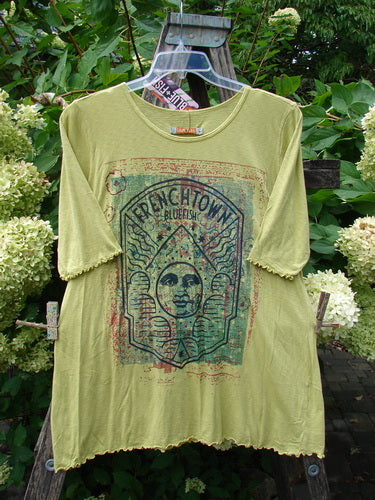 Barclay NWT Modal Slub Simple Tee Frenchtown Sun Gal Citron Size 1 displayed on a stepladder, featuring an arch-framed graphic with stylized face and palm trees.