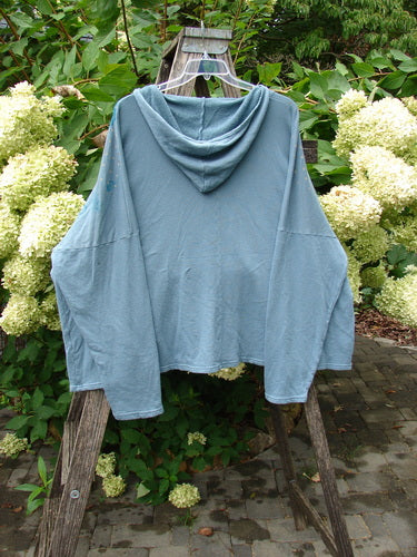 Barclay NWT Fleece Modal Hip To Be Square Hoodie Rain Flower Sea OSFA displayed outdoors, highlighting its cozy fleece, hood design, dual pockets, and domain shoulders, embodying Bluefishfinder.com's vintage, creative style.