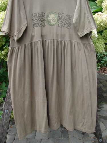1994 Flower Garden Dress Wind Medallion Bark Size 2: Loose-fitting dress with short sleeves, gathered waist, and scrolling medallion print. Draped over a wooden ladder, showcasing its whimsical garden party style.