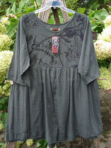 Barclay NWT Textured Terrarium Dress Contour Floral Ironworks Size 1: A dark gray, empire-seam blouse with elbow-length sleeves, featuring a subtle floral pattern around the shoulders, hanging outdoors with a BOLD FISH tag.