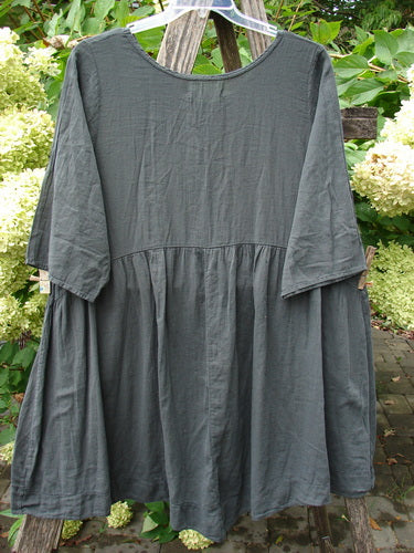 Barclay NWT Textured Terrarium Dress Contour Floral Ironworks Size 1 hangs, showcasing its scooped neckline, elbow-length sleeves, and gently gathered waist seam, highlighting its organic cotton texture and unique design.