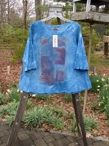 Barclay NWT Three Quarter Sleeved Cafe Tee Leaf Blend Mottled Clear Blue Sky Size 1 displayed on a wooden stand, highlighting its rounded neckline, curly edgings, and three-quarter sleeves.