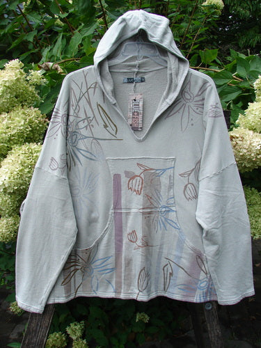 Barclay NWT Fleece Modal Hip To Be Square Hoodie Contour Floral Cloud OSFA features a hooded pullover with a V-neck, kangaroo pocket, and floral print, hanging outdoors against blooming hydrangeas.