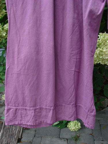 Barclay Basic Pocket Flutter Flare Pant in Unpainted Magenta Size 2, displayed against lush hydrangeas, showcasing its elastic waist, wide lowers, and distinctive flutter accents.