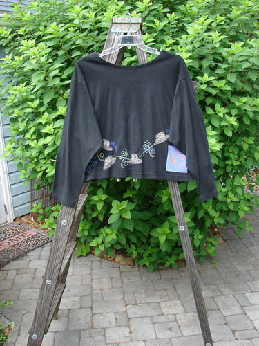 1997 NWT Long Sleeved Crop Tee Top Hat Ebony Size 2: A black shirt with a design on it, displayed on a wooden ladder.