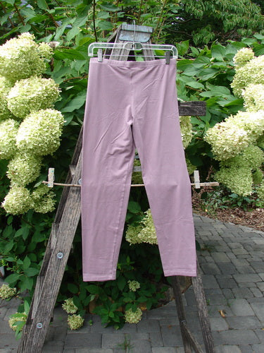 Barclay NWT Cotton Lycra Crop Legging Unpainted Tulsi Rose Size 0, draped over a rustic ladder amidst lush greenery and hydrangeas, showcasing its lightweight fabric and elegant design.