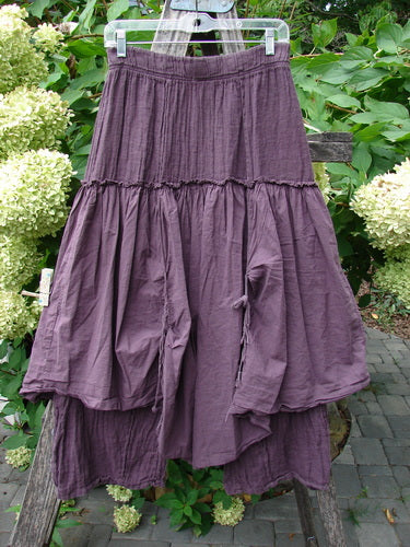 Barclay NWT Linen Batiste Fusion Pant Skirt, hung outside on a wooden trellis, showcasing its tiered design, elastic waist, and tie accents, embodying Bluefishfinder.com's vintage aesthetic and individuality.