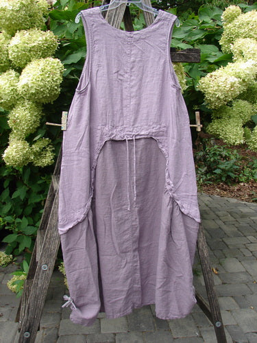 Barclay NWT Linen Explorer Jumper Tiny Botanical Sea Fog Size 0 displayed on a wooden A-frame. Features include a scoop neckline, deep side pockets, drawstring back, and billowy gathered skirt.