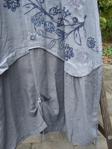 Barclay NWT Linen Explorer Jumper in Trailing Botanicals Blue River Mist Size 0, featuring a dark-blue floral print on the upper section, draped over a bench, showcasing its lightweight, flowing design and tied detail.