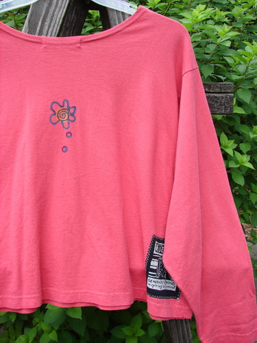 1997 Long Sleeved Crop Tee Tri Window Box Geranium Size 2: a pink shirt with a flower and sun on it, wide crop shape, drop shoulders, vented sides, and a flattened wider neckline.