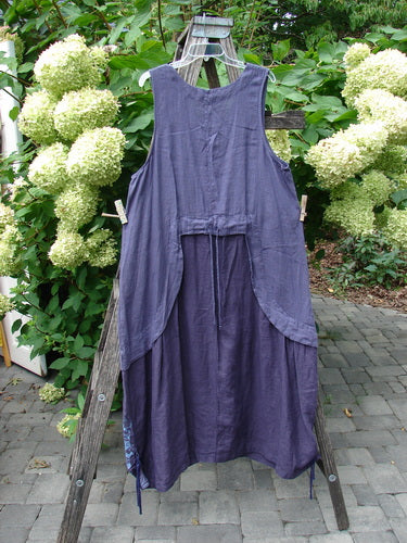 Barclay NWT Linen Explorer Jumper Botanical Blossom Purple River Mist Size 0 displayed on a wooden ladder, showcasing its sleeveless, loose-fit design with a scoop neckline and generous upper pocket.