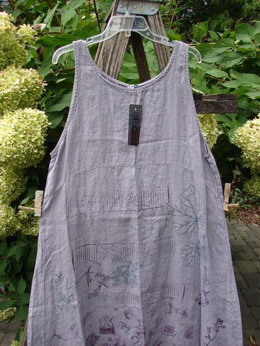 Barclay NWT Linen Sundress Garden Folly Amethyst Size 0 displayed on a hanger, featuring scoop neck, empire waist, and garden-themed motifs, set against lush greenery and white hydrangeas.