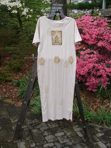 1996 Long Tee Dress Windy House Birch Bark Size 0 displayed on a wooden ladder, featuring a printed sun and swirls design, rounded paneled neckline, short wide sleeves, and seamless front and back.