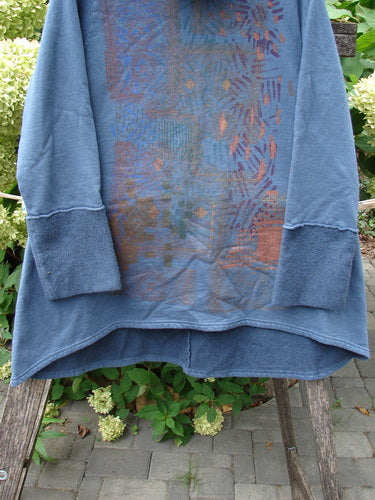 Barclay NWT Fleece Cowl Neck Sweatshirt Metallic Daisy Vintage Indigo Size 0 draped on a wooden bench, showcasing its A-lined shape, floppy cowl collar, and long wide sleeves with subtle metallic art.