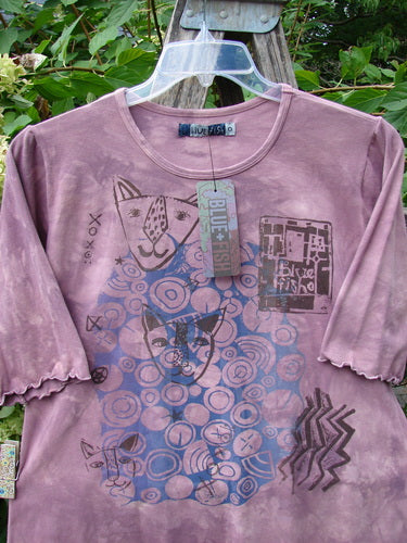 Barclay NWT Cotton Lycra Horizon Tee BF Logo Cats Mottled Pinkberry Size 0, featuring a stylized cat graphic, concentric circles, and abstract patterns, displayed on a clear hanger in a garden setting.