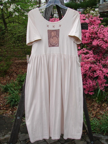 1996 Short Sleeved Simple Dress Pear Birch Bark Size 0 hanging on a clothesline, showcasing a rounded neckline, drop empire waist seam, and full sweeping skirt with a signature blue fish stamp and pear garden theme.