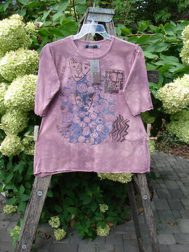 Barclay NWT Cotton Lycra Horizon Tee with abstract motifs, hung on a ladder outdoors. The tee features a unique design embodying the Blue Fish creative spirit, perfect for expressing individuality.