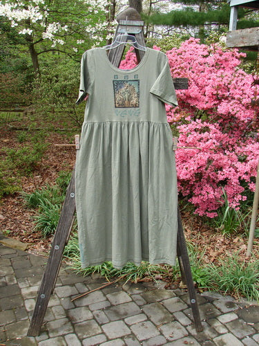 1996 Short Sleeved Simple Dress Sunflower Cricket Size 0 displayed on a wooden ladder, featuring a deeper rounded neckline, drop empire waist seam, and full sweeping skirt with sunflower garden theme paint.