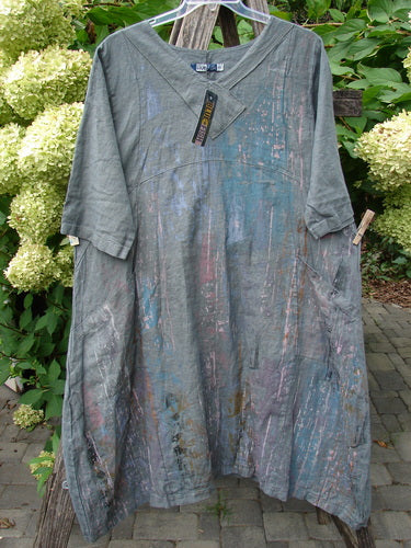 Barclay NWT Linen Cross Over Urchin Pocket Dress Vertical Rain Smudge Stick Size 0, featuring a loose cut, V-neckline, elbow-length sleeves, side pockets, displayed on a rustic wooden trellis.