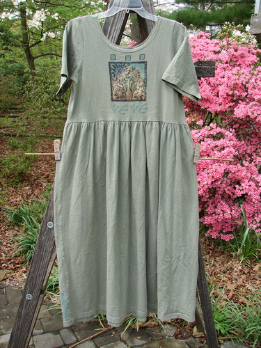 1996 Short Sleeved Simple Dress Sunflower Cricket Size 0 hanging on a clothesline, featuring a deeper rounded neckline, drop empire waist seam, full sweeping skirt, and sunflower garden theme paint.