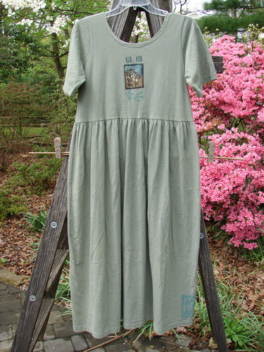 1996 Short Sleeved Simple Dress Sunflower Cricket Size 0 on a clothes rack, featuring a deeper rounded neckline, drop empire waist seam, and full sweeping skirt with Blue Fish's Sunflower Garden Theme.