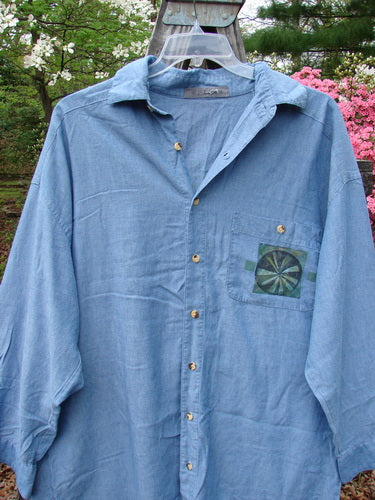 1998 Men's Lightweight Brushed Cotton Long Sleeved Oxford Shirt Earth Indigo Size XL displayed on a hanger, featuring a front painted breast pocket, longer cuffed sleeves with tiny button closures, and a rounded hemline.