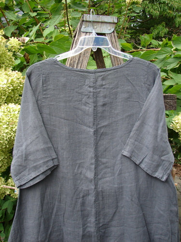 Barclay NWT Linen Lucida Top Unpainted Diatom Size 0, featuring a flowy A-line shape, rounded neckline, and almost three-quarter sleeves, displayed on a hanger against a natural backdrop.