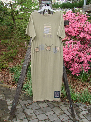 1996 Long Tee Dress Pathway Cricket Size 0 displayed on a wooden ladder, featuring a rounded paneled neckline, straight shape, pegged vented hemline, seamless front and back, and short wide sleeves.