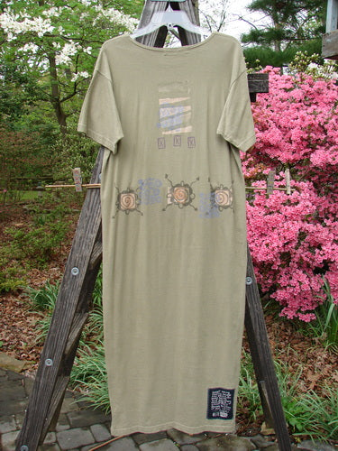 1996 Long Tee Dress Pathway Cricket Size 0 displayed on a wooden rack, featuring a rounded paneled neckline, longer straighter shape, short wide sleeves, and signature Blue Fish patch with garden pathway theme.