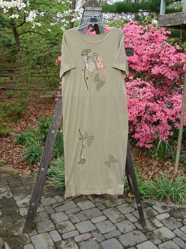 1996 Long Tee Dress Butterfly Cricket Size 0 on a wooden ladder, showcasing a rounded paneled neckline, seamless front and back, short wide sleeves, and a slightly narrowing vented hemline.