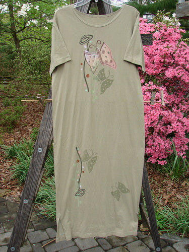 1996 Long Tee Dress Butterfly Cricket Size 0 displayed on a wooden ladder, highlighting its organic cotton fabric, rounded paneled neckline, short wide sleeves, seamless front and back, and classic butterfly theme.