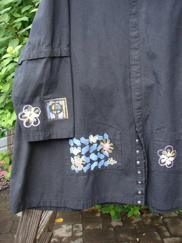 2000 Parachute Camper Jacket with floral theme, black, size 2. A close-up of a dress made from wondrous cotton parachute fabric.