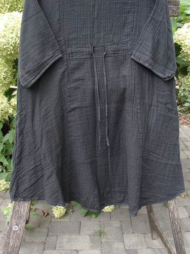 Barclay NWT Gauze Keyhole Bliss Pocket Dress Unpainted Black Size 0 draped over a stool, showcasing its keyhole neckline, drawstring waist, flared skirt, and triangular drop pockets in soft cotton gauze.