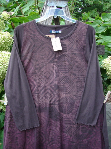 Barclay NWT Natalia Tunic Grid Pod Red Peat Size 0, featuring a geometric print, round neckline, and lettuce-edge sleeves, hangs outdoors with a price tag, showcasing its new condition.
