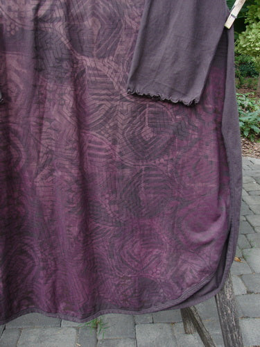 Barclay NWT Natalia Tunic Grid Pod Red Peat Size 0 displayed on a wooden rack, featuring a rounded neckline, rounded lower hemline, longer sleeves with lettuce edges, and high rounded side vents.