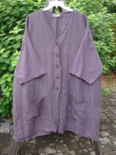 Barclay Linen Cotton Sleeve Pocket Cardigan Unpainted Dusty Plum Size 2: A medium weight cardigan with wooden buttons, drop shoulders, and squared off pockets. Curly lower sleeves and a widening lower shape give it a unique look.