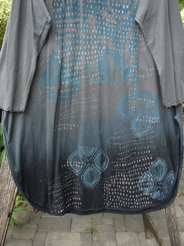 Barclay NWT Natalia Tunic Rain Pod Twilight Grey Size 0, a dark gray long-sleeved tunic with a blue and white abstract pattern on the lower half, hangs on a wooden ladder outdoors.
