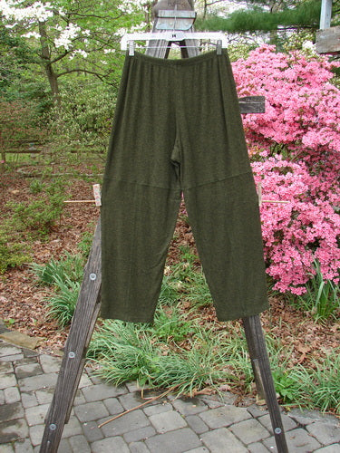 2000 Rayon Lycra Rib Quadrant Pant Unpainted Green Oak Heather Size 0 hanging on a wooden fence outside, showcasing its full elastic waistline, cropped shape, and unique knee accents.