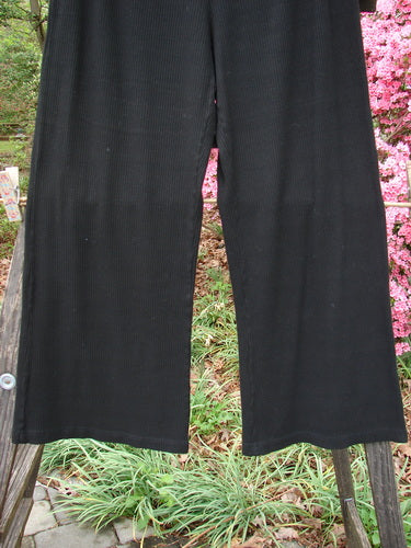 2000 Rayon Lycra Rib Flare Pant Unpainted Black Size 0 displayed on a wooden fence, showcasing its full elastic waistline, slightly flared bottom, and superior drape.