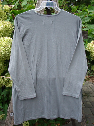 Barclay NWT Long Sleeved Studio Tee, featuring a straighter shape and rounded neckline, displayed on a hanger outdoors against green foliage. Made from medium-weight organic cotton, perfect condition, size 0.