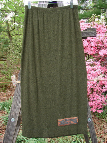 2000 Patched Rayon Lycra Rib Linear Skirt Green Oak Heather Size 0 displayed on a wooden stand, showcasing its full elastic waistband, slightly flared lower shape, and detailed exterior horizontal hem stitchery.