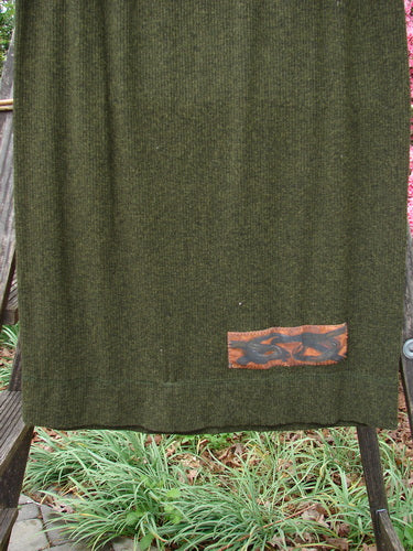 2000 Patched Rayon Lycra Rib Linear Skirt Green Oak Heather Size 0 displayed draped on a wooden ladder, showcasing its elastic waistband and slightly flared lower shape with exterior horizontal hem stitchery.