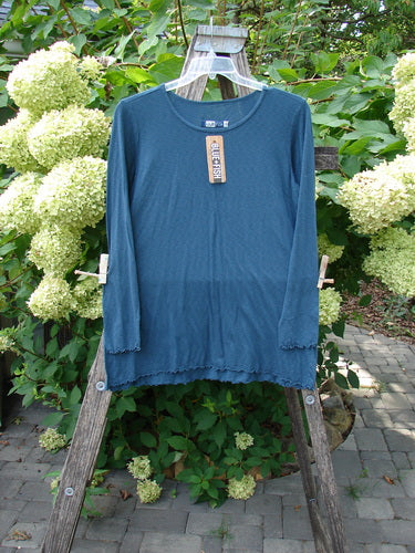 Barclay NWT Modal Slub Long Sleeved Simple Tee displayed on a hanger over a wooden ladder, showcasing its long, slightly narrow sleeves, A-line shape, and raw edges, embodying BlueFishFinder's vintage ethos.